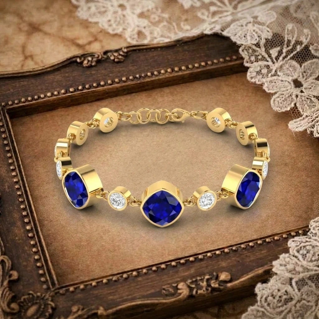 Bezel set cushion cut blue sapphires alternated with round diamonds on a gold plated chain link bracelet