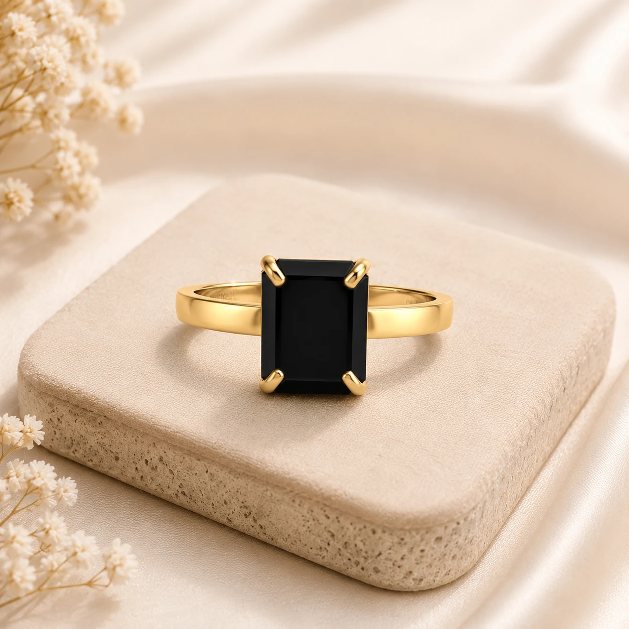 Classic emerald cut black diamond solitaire ring with four prongs on a gold plated band