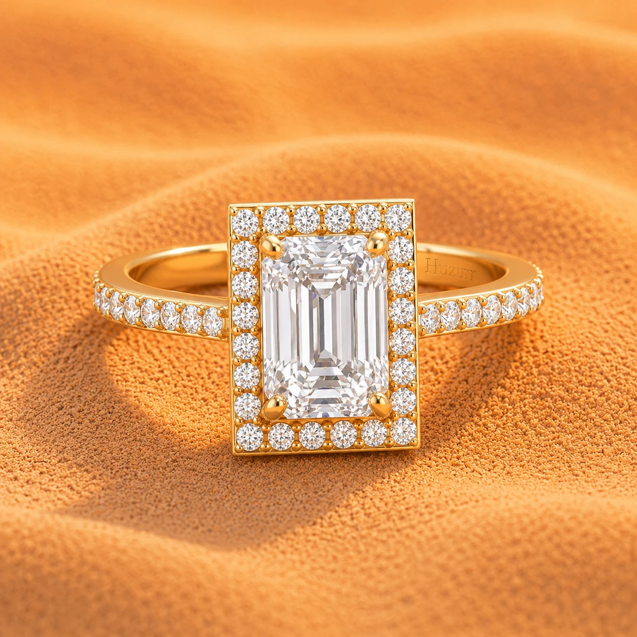 Emerald cut diamond ring with a rectangle halo of small diamonds on a gold plated shiny band.