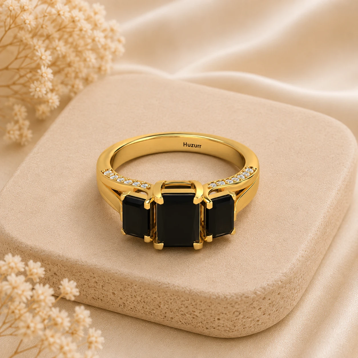 Three stone emerald cut black diamond ring in gold plated setting with white diamond accents on the band