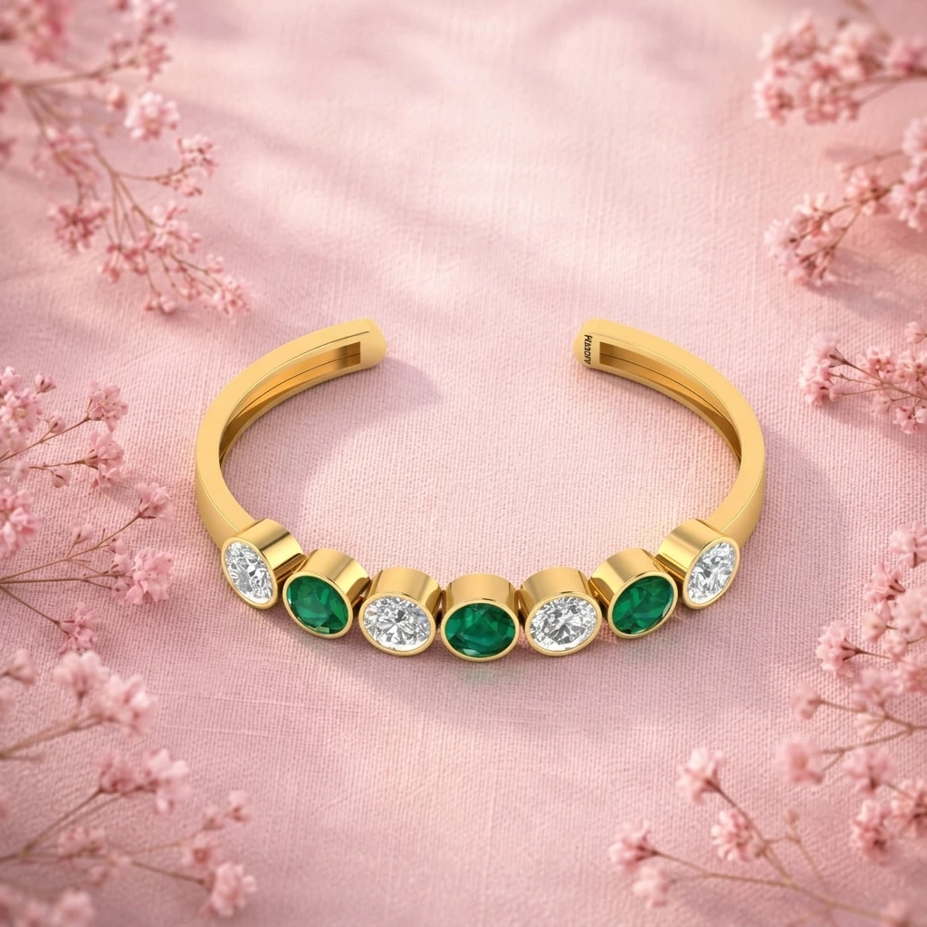 Alternating emerald stones and diamonds on an open gold plated cuff bracelet