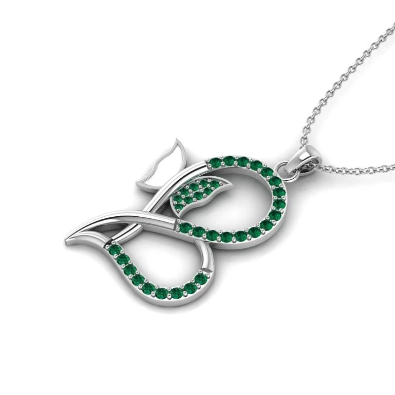 white enamel butterfly heart necklace featuring an artistic silhouette lined with small round green emerald gemstones