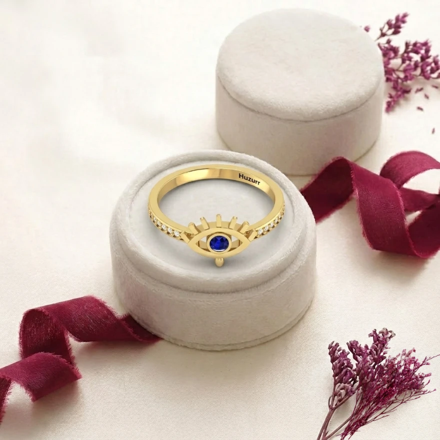 Evil eye  ring set with a round blue gemstone pupil and a diamond paved gold plated band