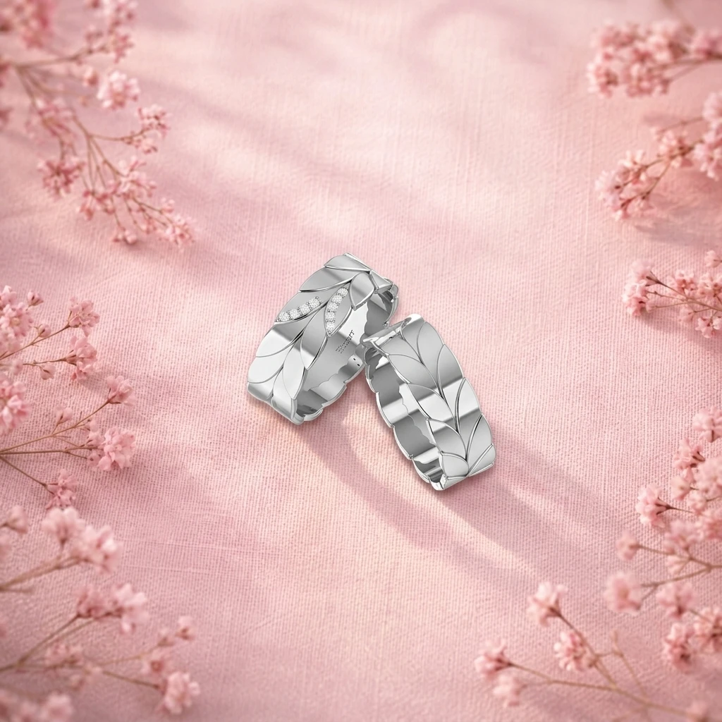 Matching wedding silver band set featuring a sculpted laurel leaf pattern with round diamond accents on one ring