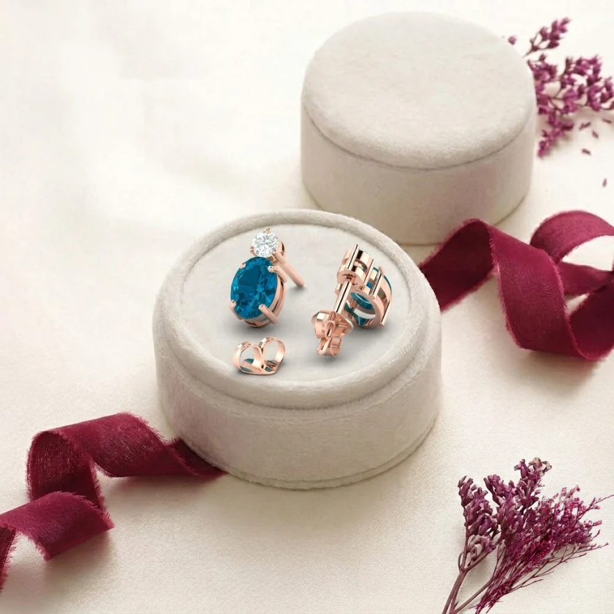 Rose gold plated stud earrings featuring oval London blue topaz stones and round diamond tops