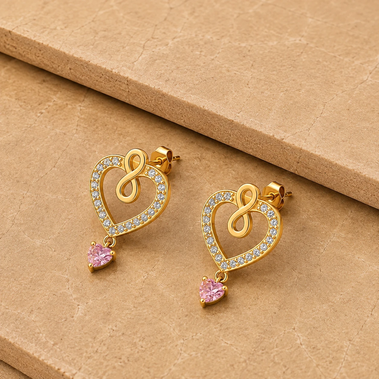 Open heart gold plated earrings with an infinity motif, diamond border, and dangling pink heart morganite