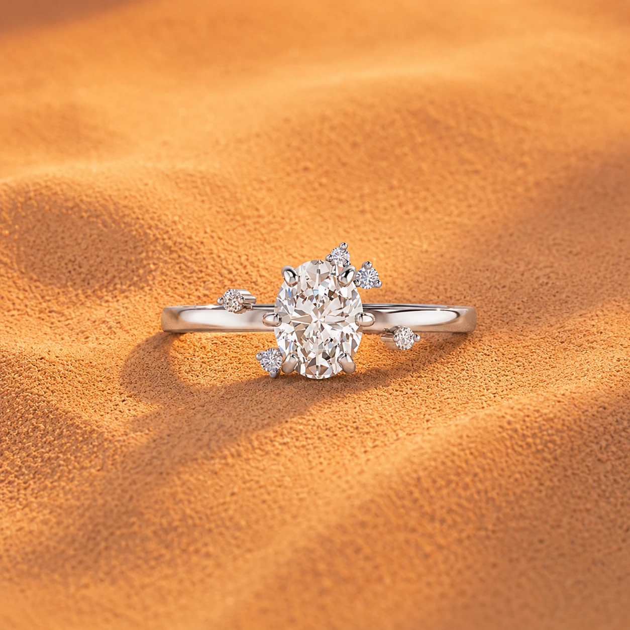 Oval diamond ring made of 925 silver with small groups of tiny diamonds on the sides.