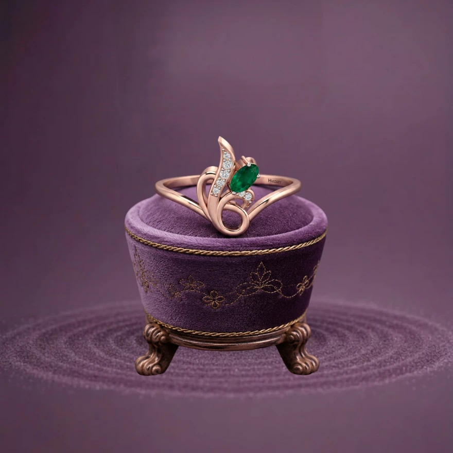 A classic-style ring featuring a deep green, oval-cut emerald set in warm two-tone rose gold-plated metal.