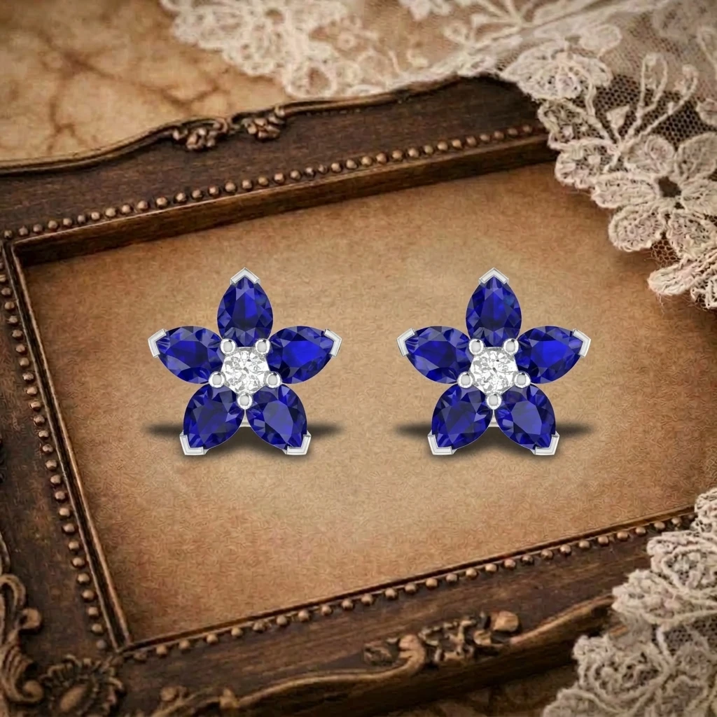 Pair of silver flower stud earrings featuring pear cut blue sapphire petals and a round diamond center stone