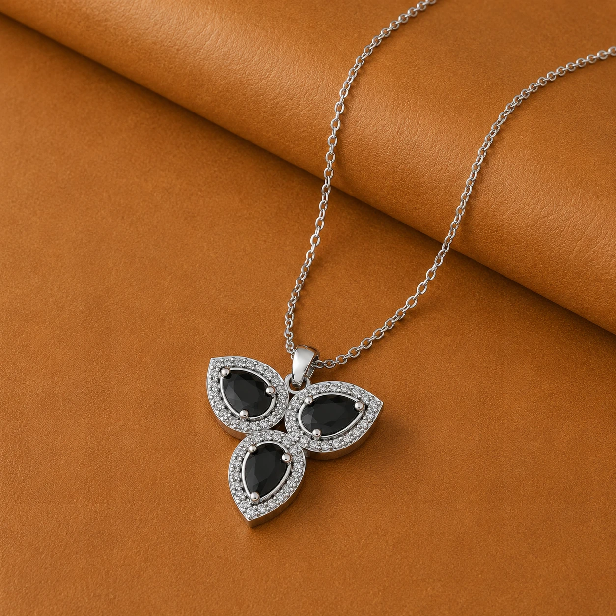 Three pear shaped black diamond solitaire stones with halo diamond borders set in 925 sterling silver.