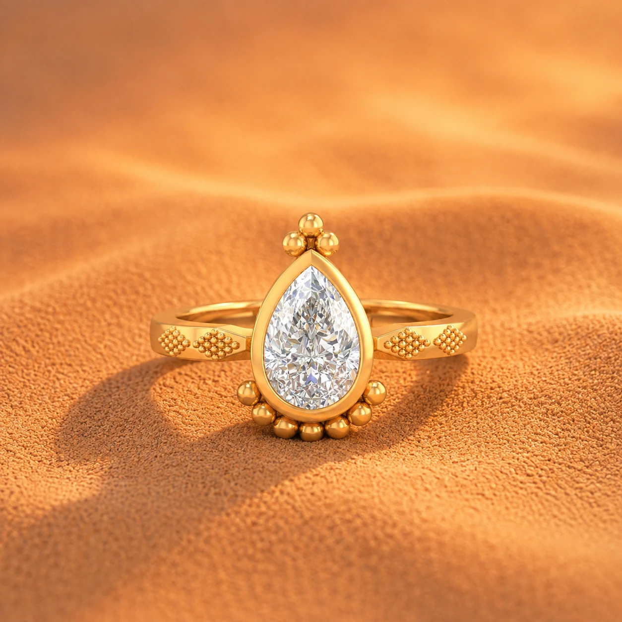 Pear shaped diamond ring in a gold plated bezel setting with antique-style metal bead