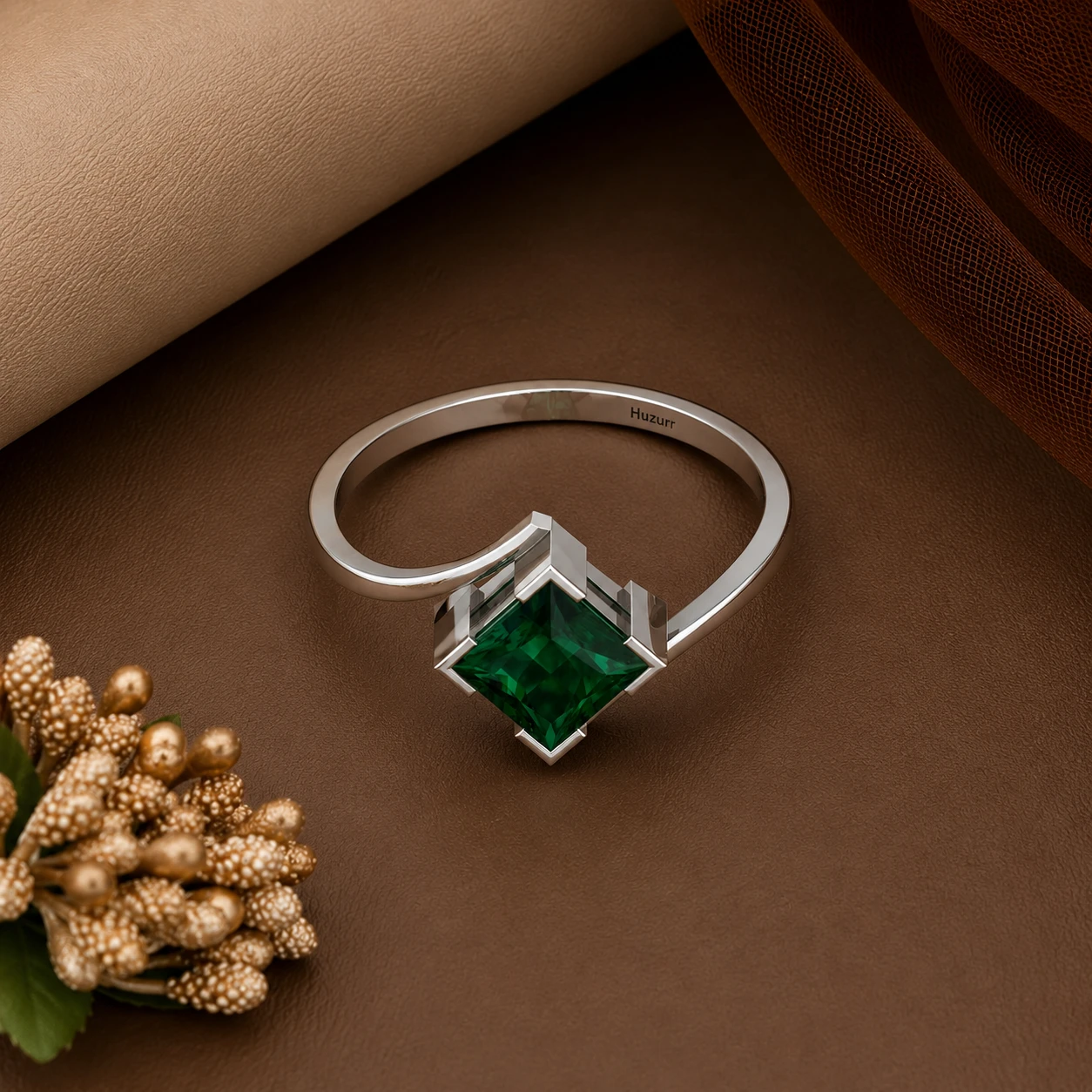 Vibrant princess-cut green emerald solitaire stone mounted on a modern wavy sterling silver band