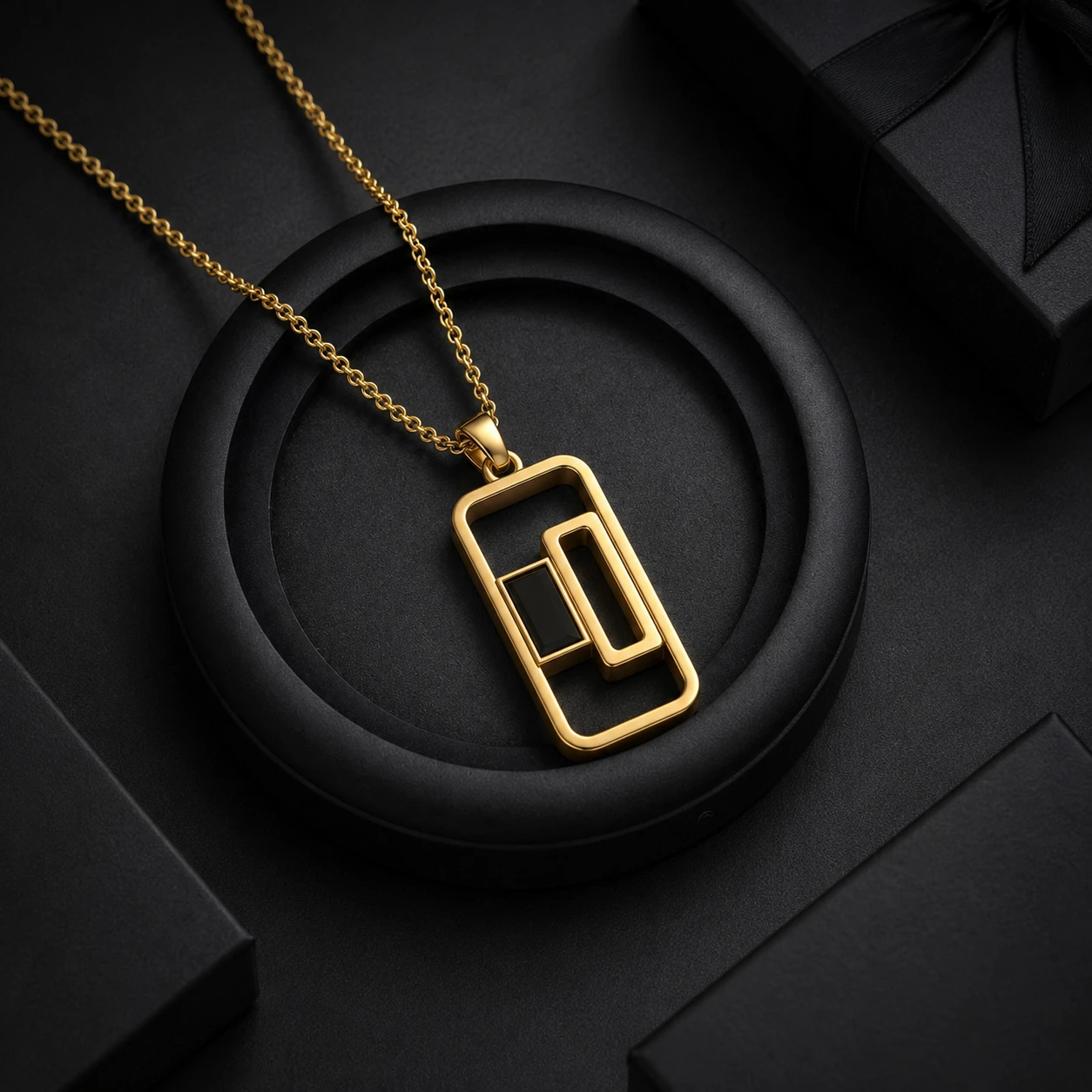 Open rectangle necklace pendant holding a single baguette-cut black diamond stone in yellow gold plating