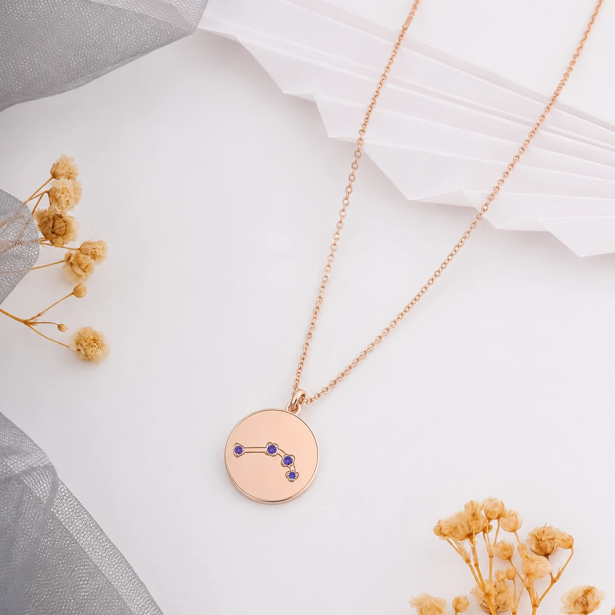 Round rose gold plated medallion pendant showing purple amethyst zodiac stars