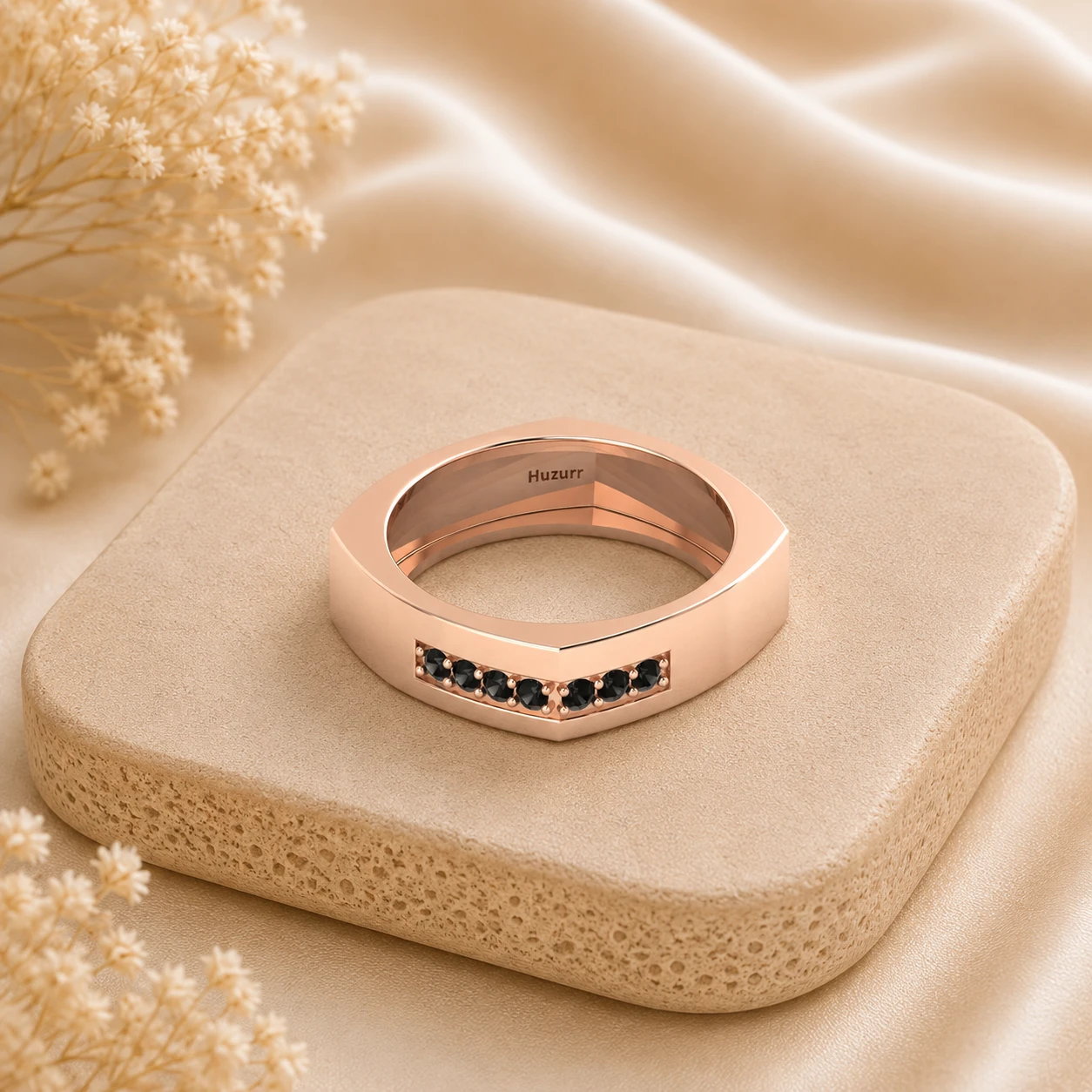 Square shaped rose gold plated band featuring a channel setting of seven round black diamonds