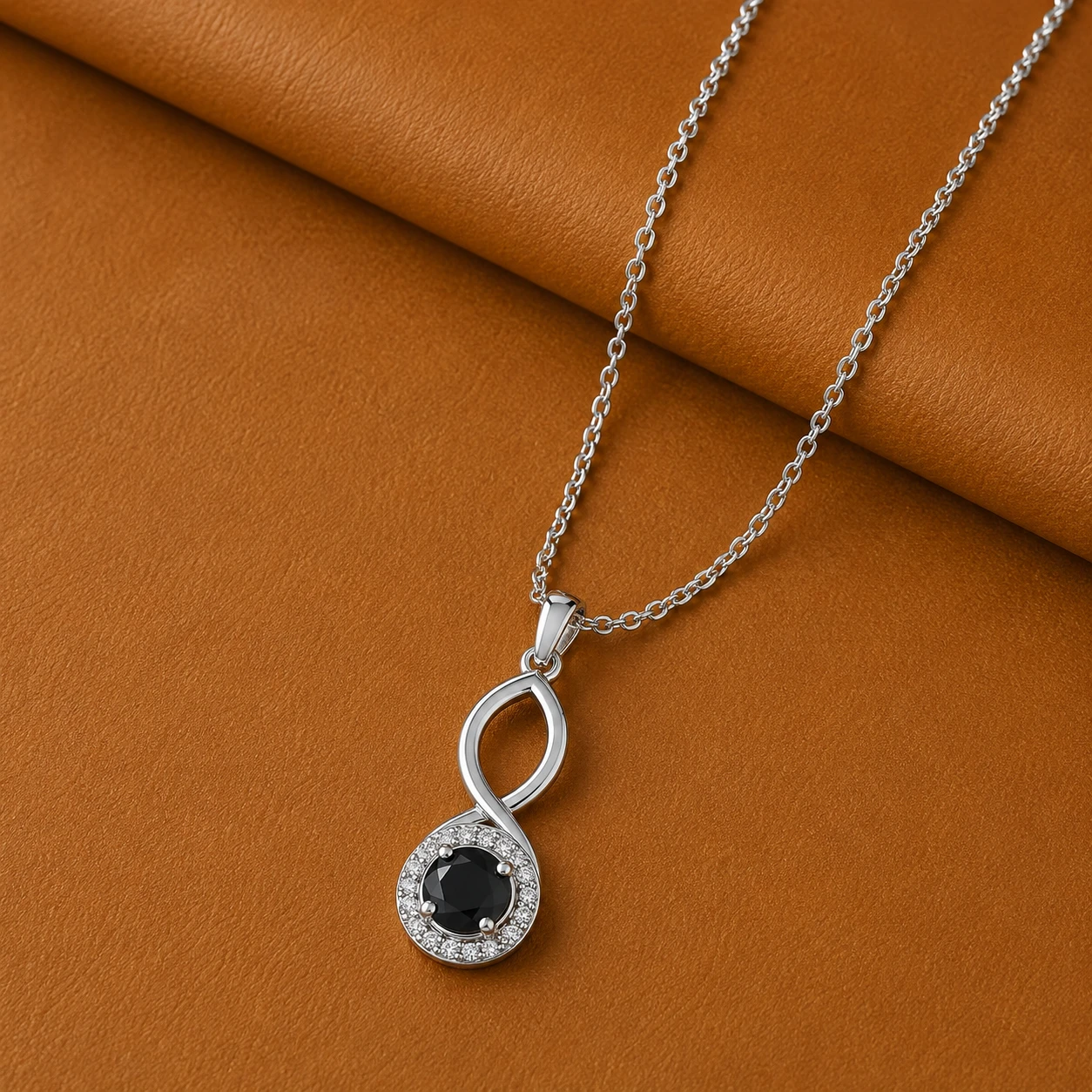 Vertical silver infinity loop necklace featuring a round black diamond solitaire base with a diamond halo.