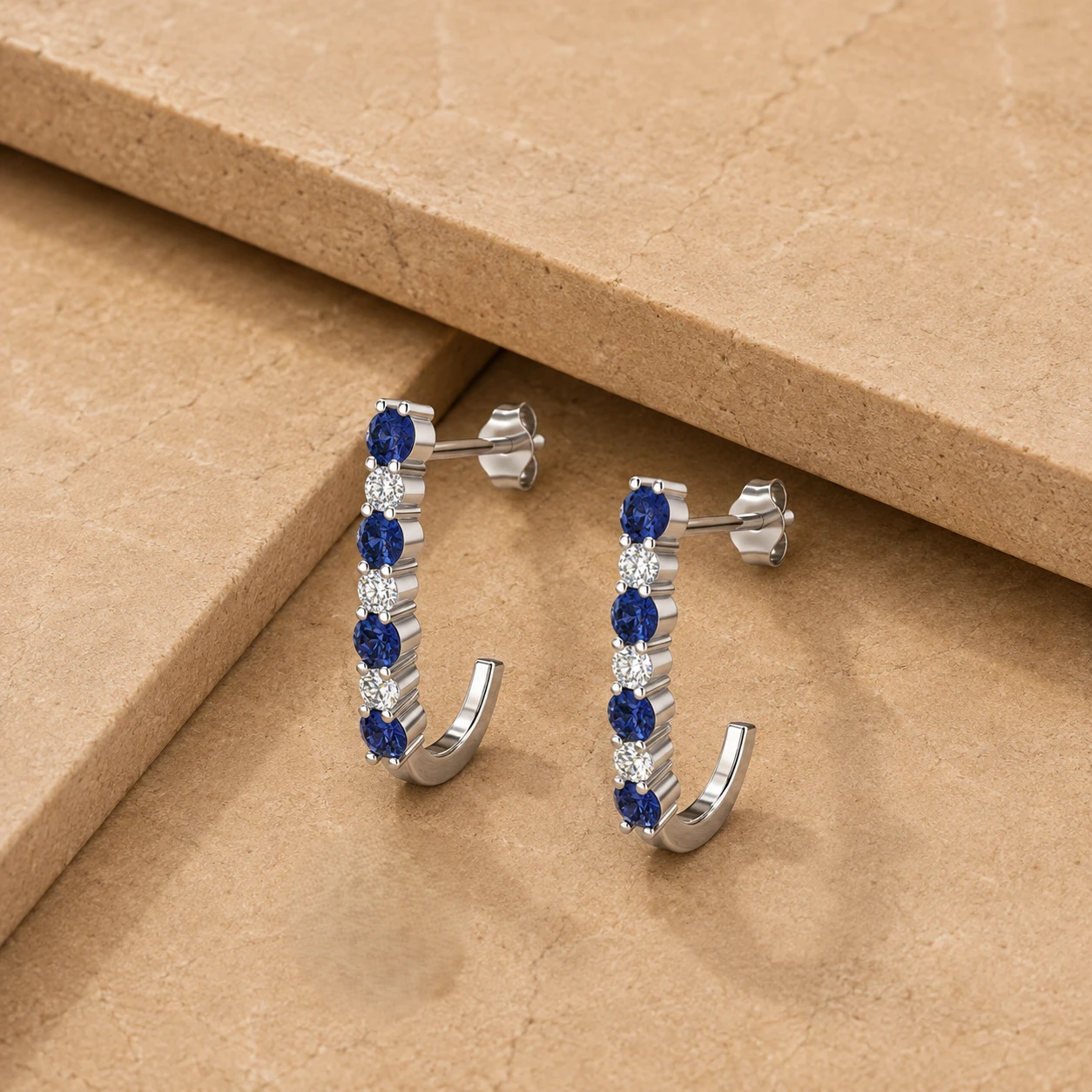 Sterling silver open J hoop stud earrings lined with alternating round tanzanites and diamonds