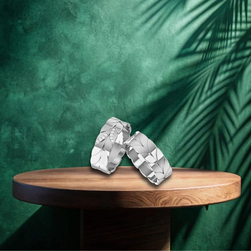 Custom name text lines the inside of two silver leaf rings, one featuring small diamond accents