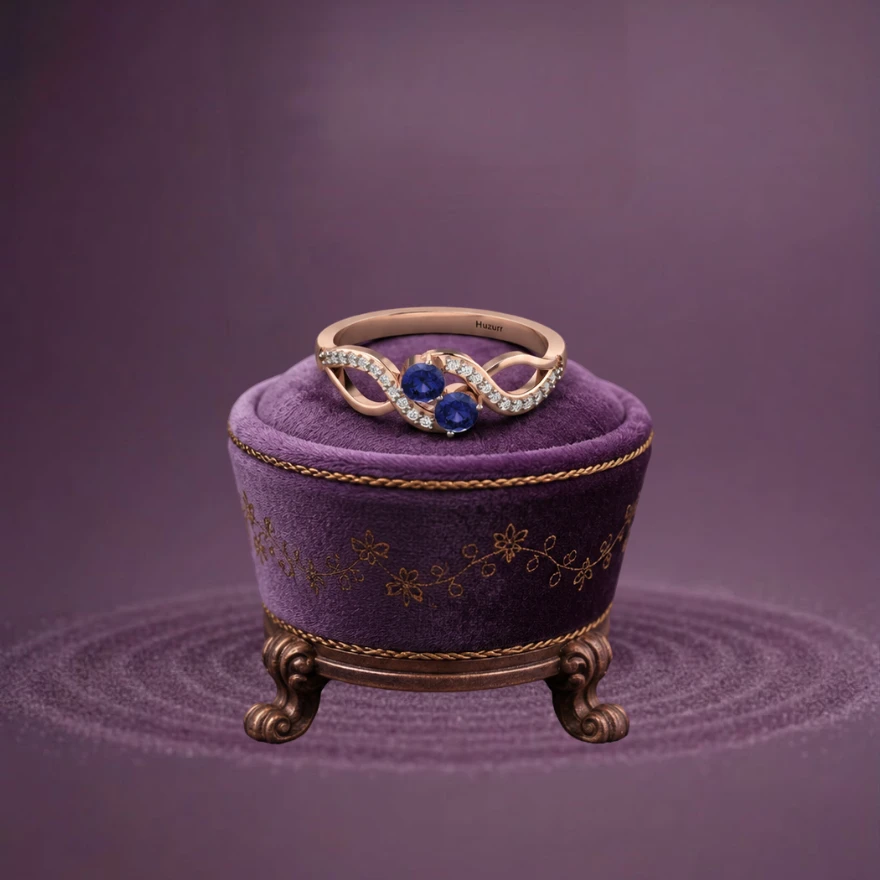 Two purple-blue tanzanite stones embedded in a contemporary rose gold-plated infinity loop two-tone band
