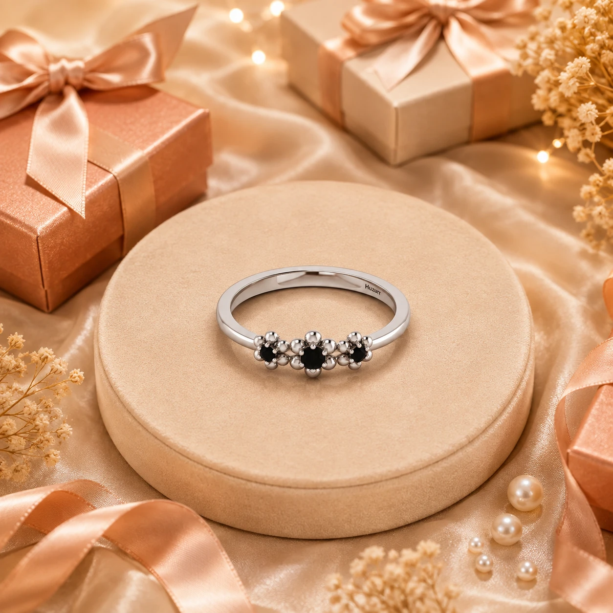 Three-beaded metal flower ring centered with three-round black diamonds on a polished silver band