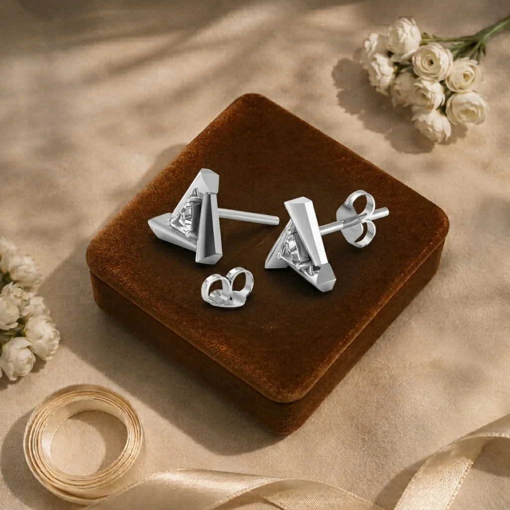 Silver stud earrings featuring a trillion-cut diamond set in the center of an open triangular frame.