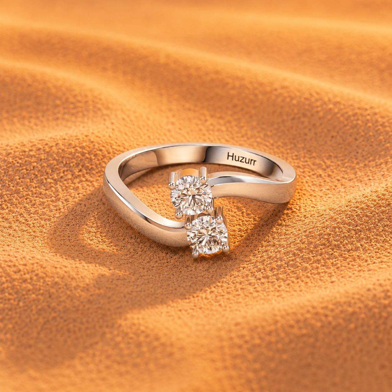 Simple silver ring with two round bright diamonds set together on a curved bypass band.
